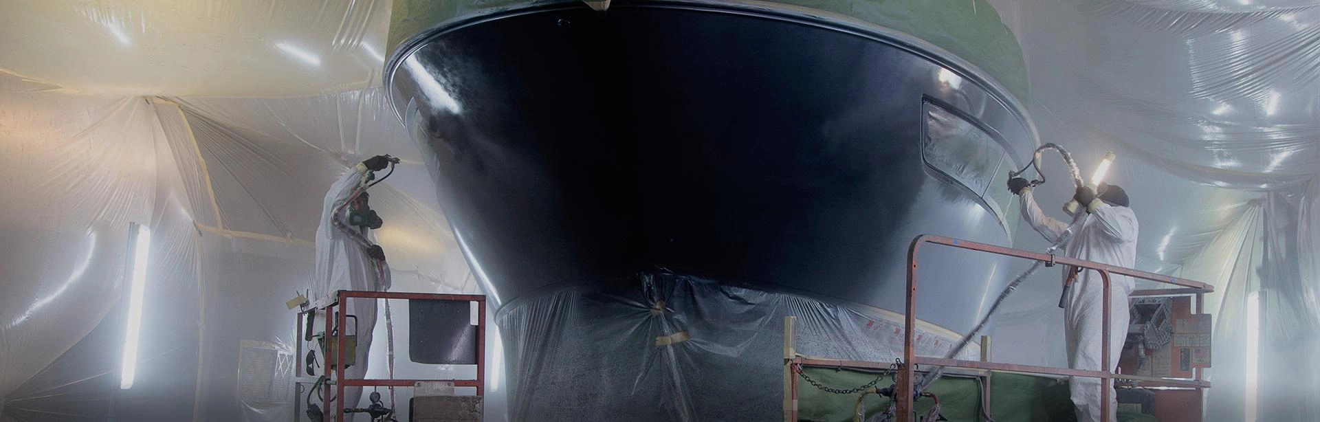 Specjalista malujący łódź na czarny kolor